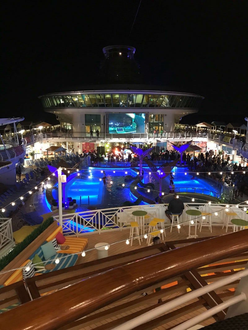 All night partiers onboard the Navigator of the Seas looking down at pool area