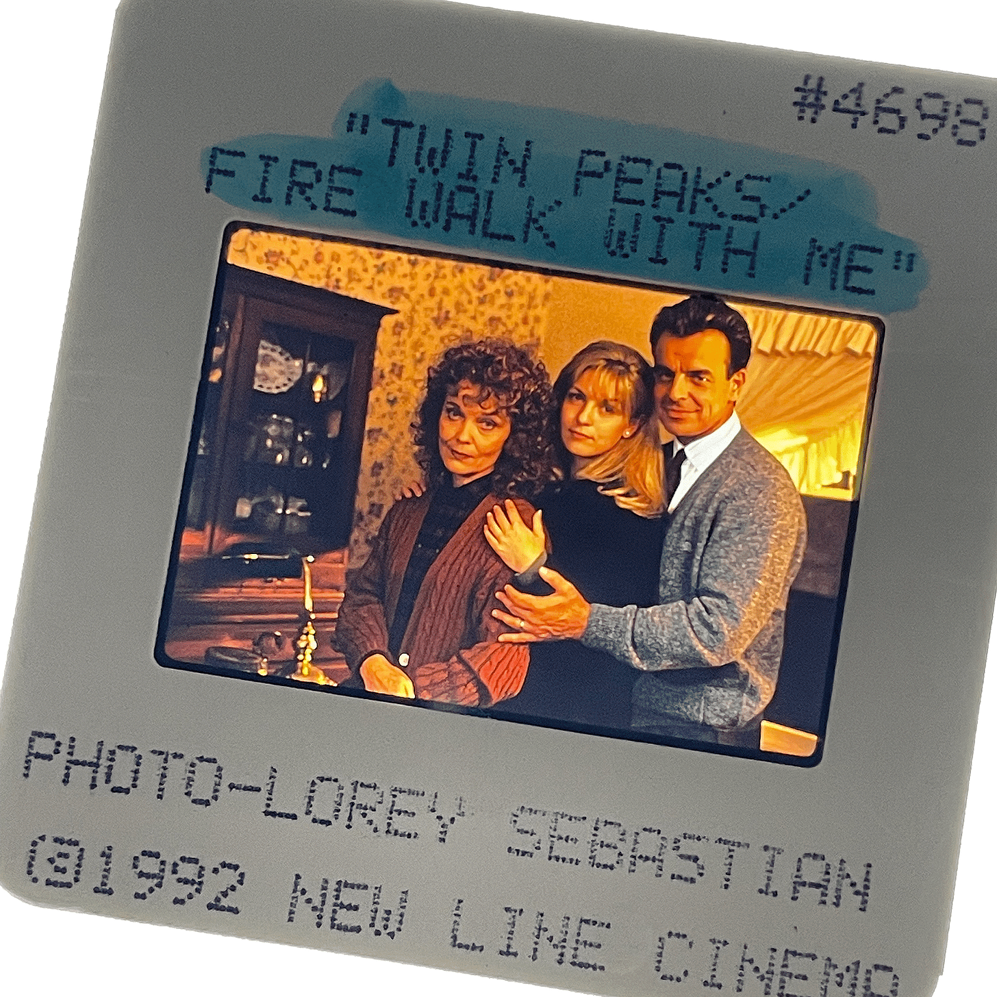 A color slide from Twin Peaks: Fire Walk With Me, taken by Lorey Sebastian. Shows Grace Zabriskie, Sheryl Lee and Ray Wise posed for a normal suburban family portrait.