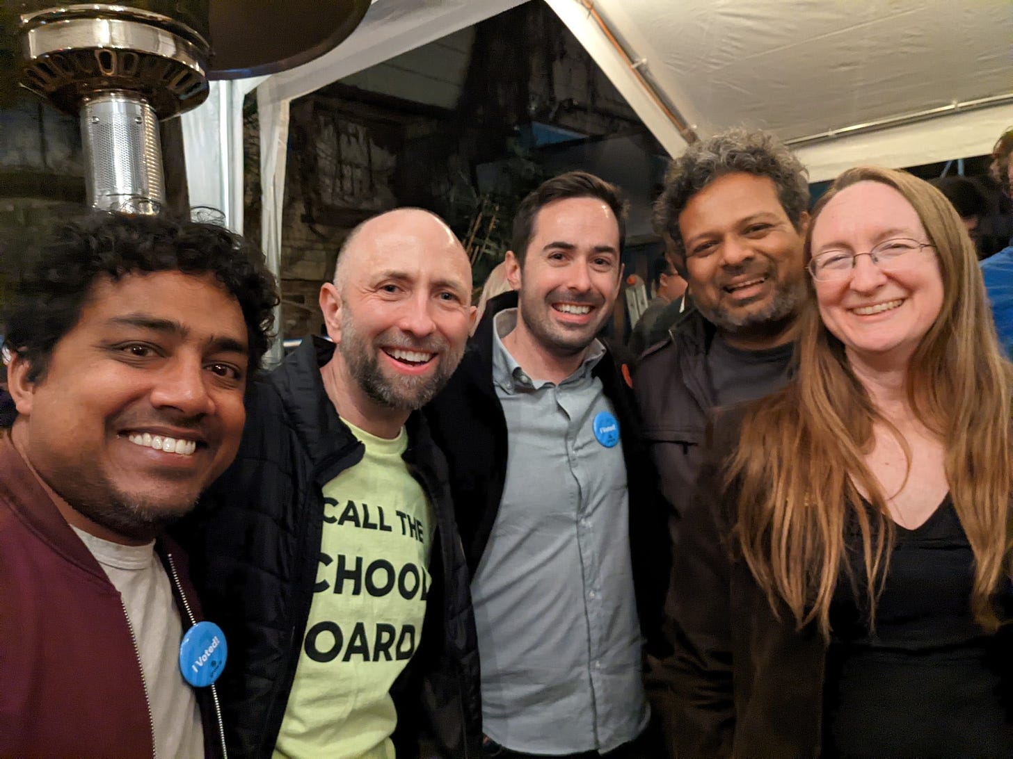 five smiling people, in a row, at an election night party