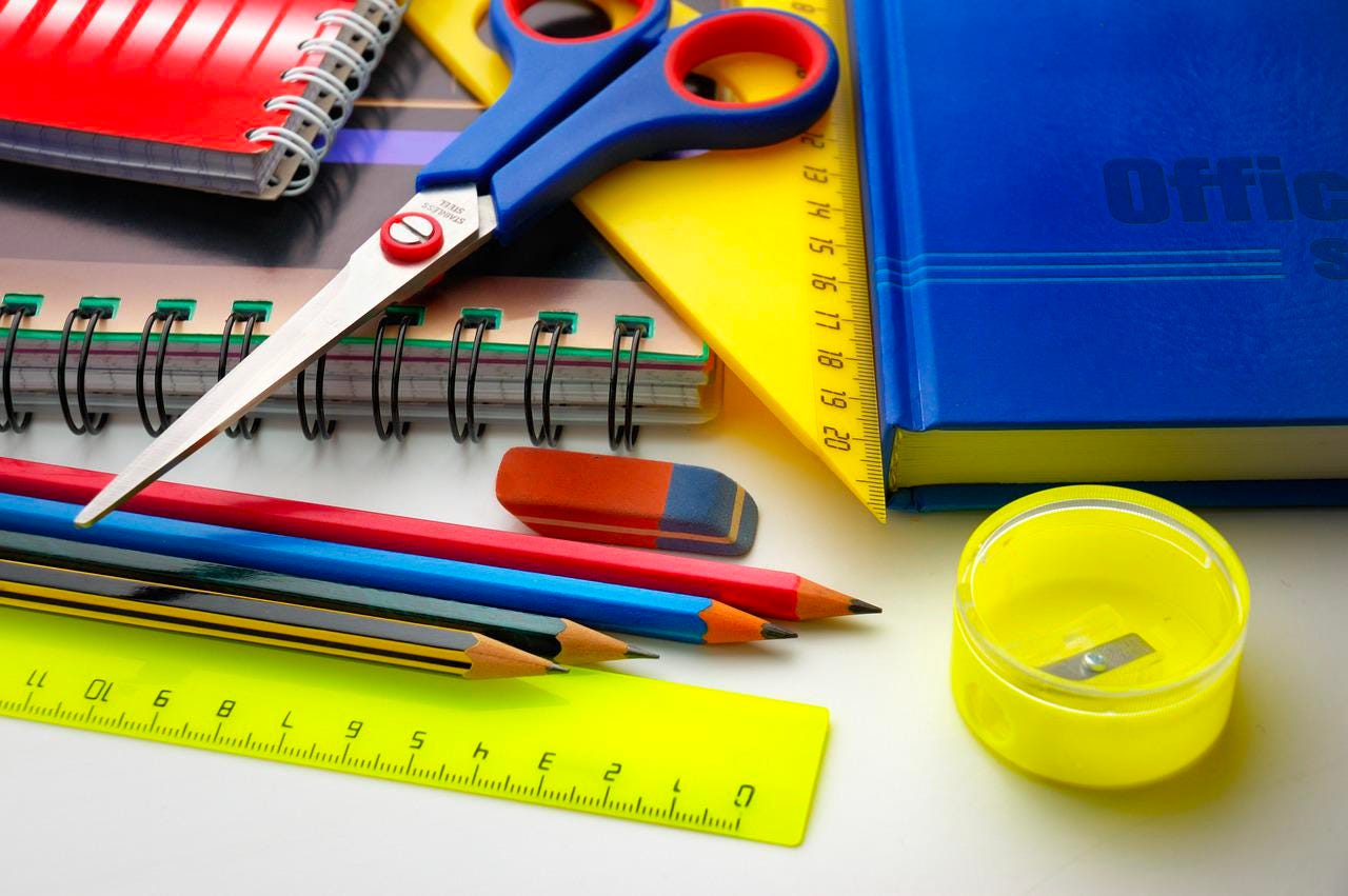 assorted office supplies - pencils, ruler, notebooks, scissors, pencil sharpener