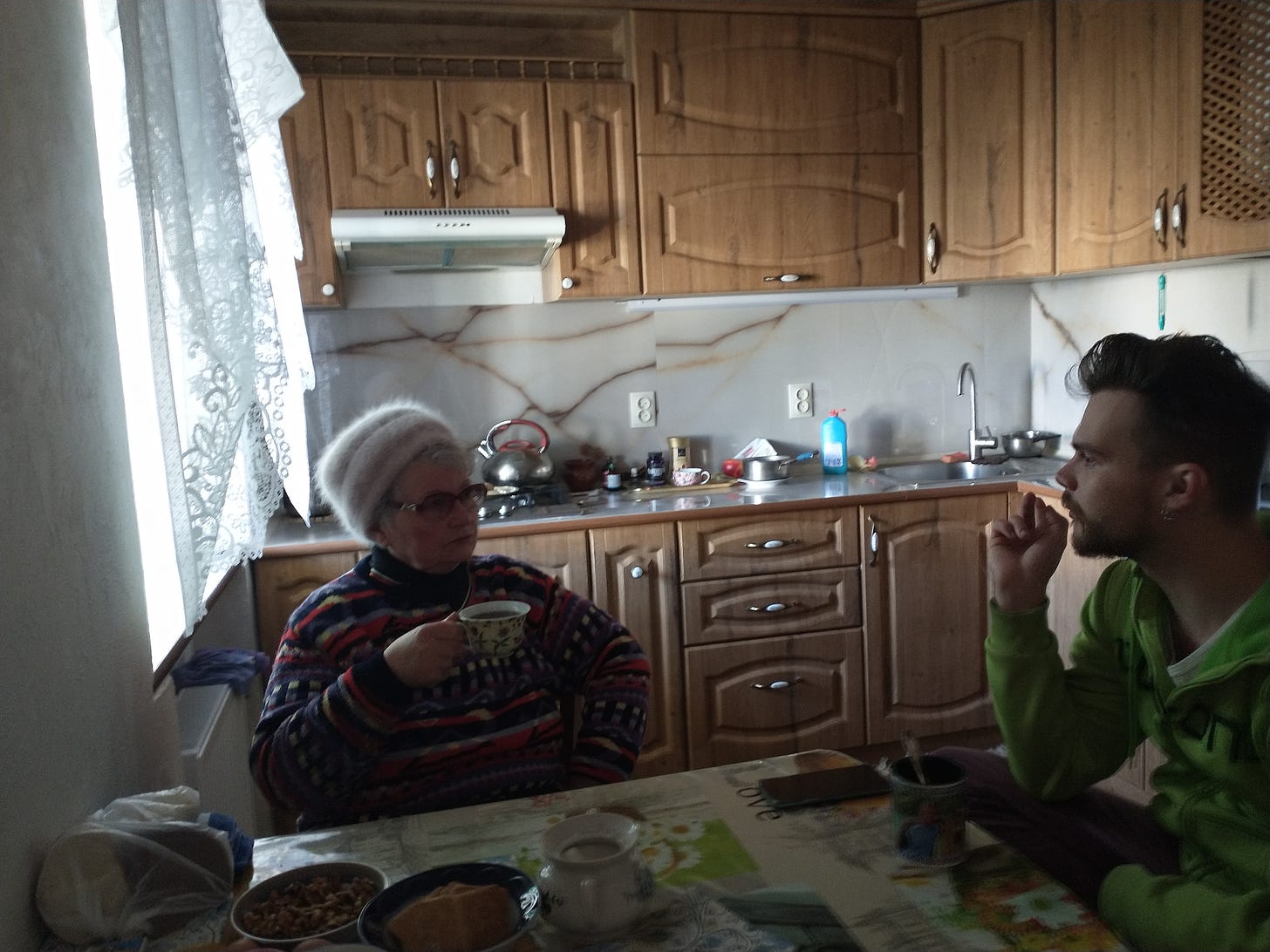 Luda Logachevskaya, Mykolaiv resident and her grandson drink tea in her kitchen and discuss the war