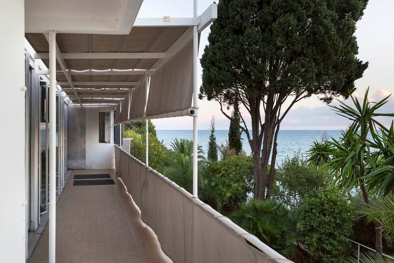 Exterior porch with a view of the ocean and trees. 