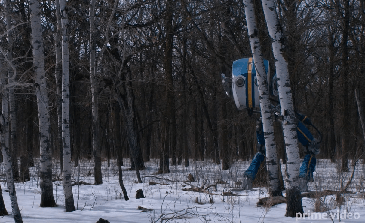 A mysterious robot peers out from the forest.