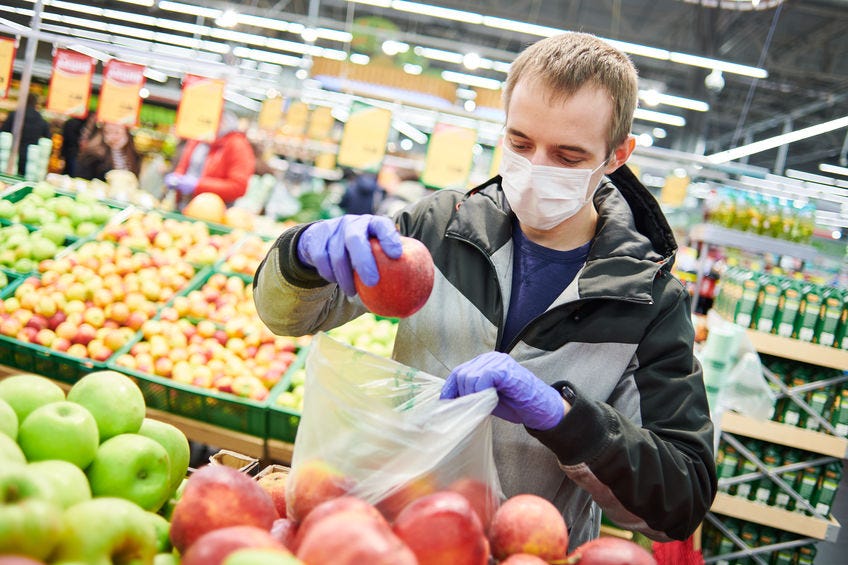 man in mask and protective gloves buying and living a healthy lifestyle