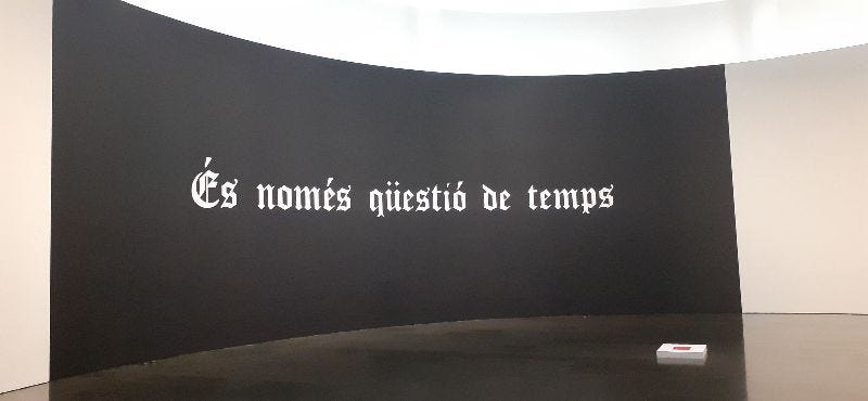 La versione catalana dell'opera "It's just a matter of time": è una grande opera murale con sfondo nero su cui campeggia una scritta bianca in carattere gotico che dice "És només qüestió de temps".
