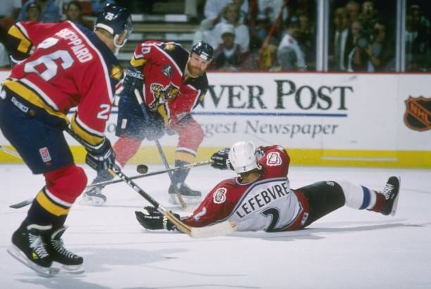 Dave Lowry of the Florida Panthers passes to teammate Ray Sheppard as Sylvain Lefebvre of the Colorado Avalanche tries to break up the pass during...