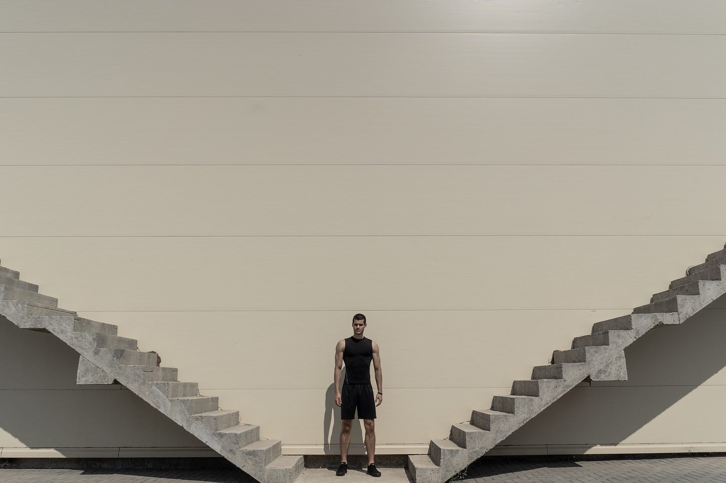 A man stands between two sets of stairs and is faced with deciding which way to go.