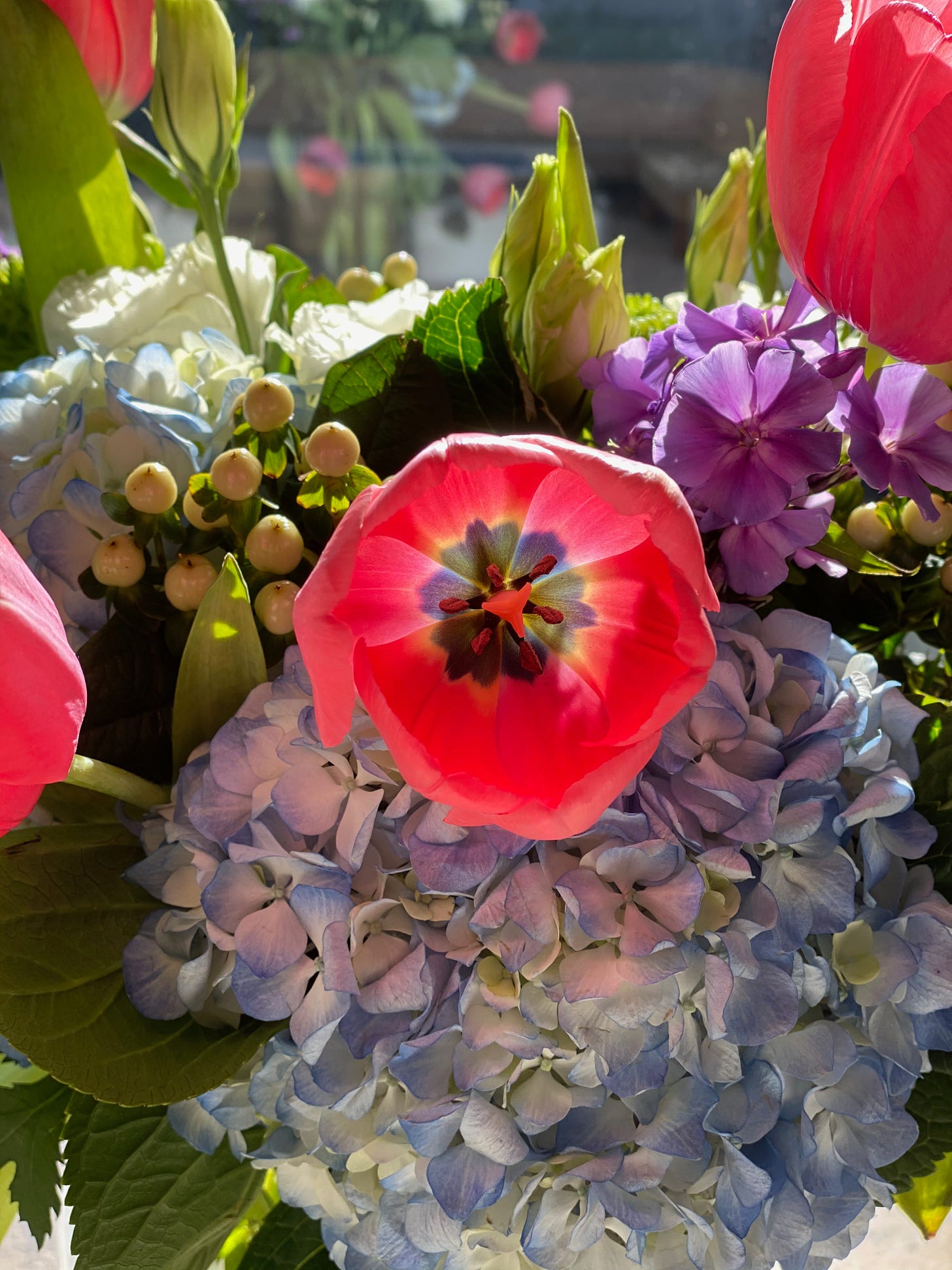A bouquet of flowers, with a large pink one at the center.