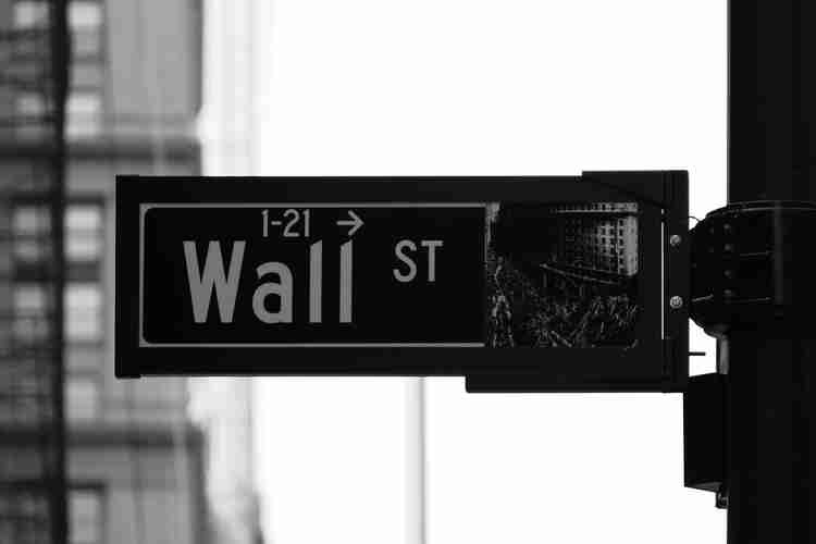A sign board which states " wall street"