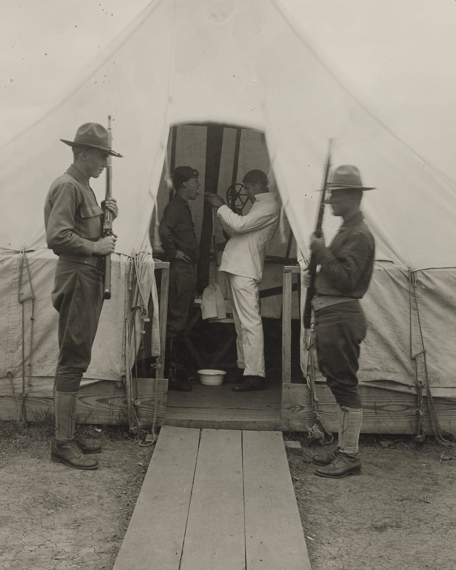 https://upload.wikimedia.org/wikipedia/commons/3/3a/1918_at_Dallas_Love_Field%2C_Spanish_flu_in_the_United_States%2C_Soldiers_of_the_United_States_detail%2C_from_-111-SC-27625_-_NARA_-_55214723_%28cropped%29.jpg