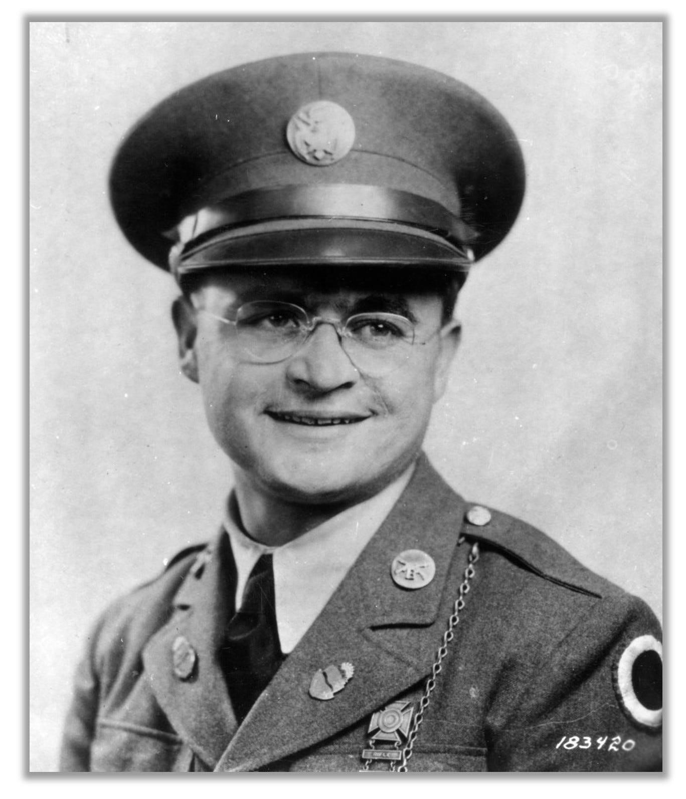 Black and white photo of Rodger Young in uniform.  He is wearing glasses that make him look more like a professor than a military hero.