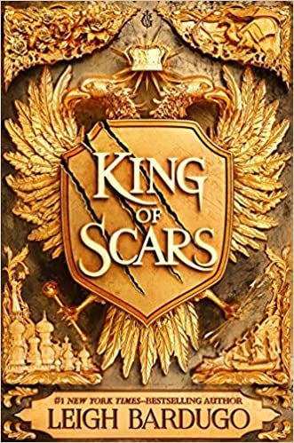 The book cover for King of Scars by Leigh Bardugo. The cover is covered in gilded gold designs and a double headed golden eagle whose wings are spread wide and hold a shield with the title scrawled across it. 
