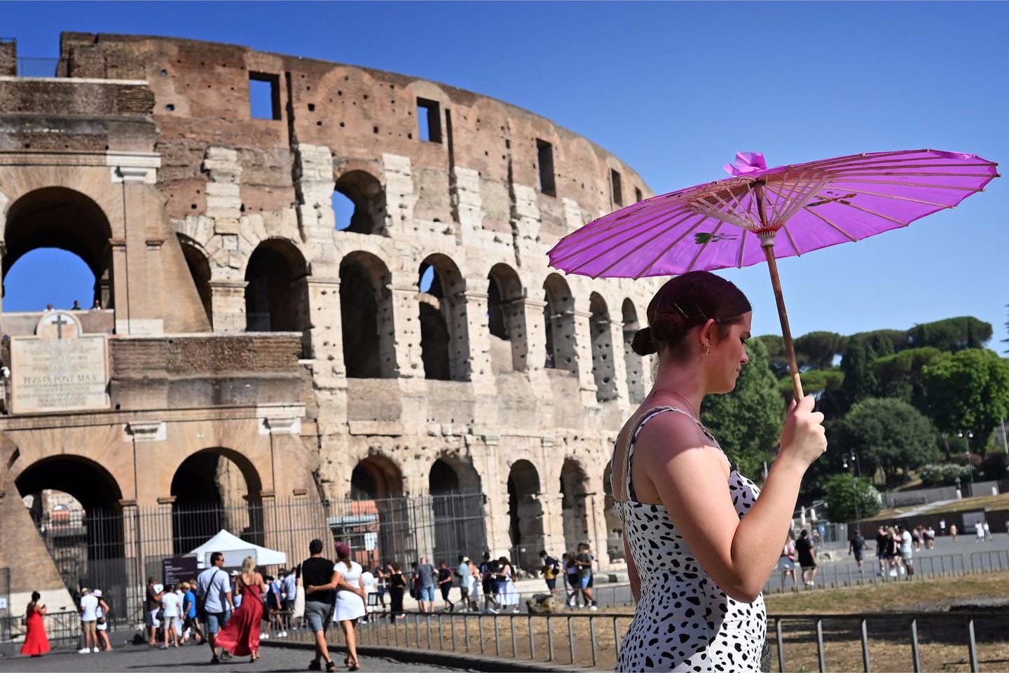 A woman used an umbrella to shield herself from the sun outside the Colosseum in Rome Thursday. Rome was among 15 Italian cities that received warnings from the health ministry about high temperatures and humidity with peaks predicted for Friday.