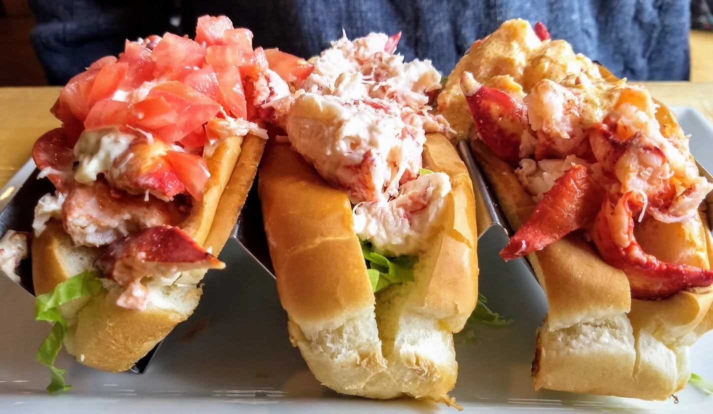 Three lobster rolls with different toppings