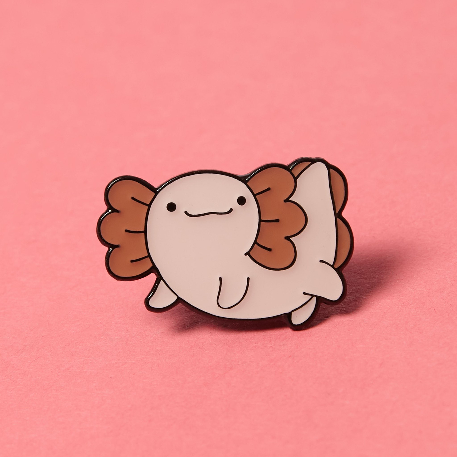 An enamel pin, of a smiling animal of some kind. Don't ask me, I'm not a zoologist.