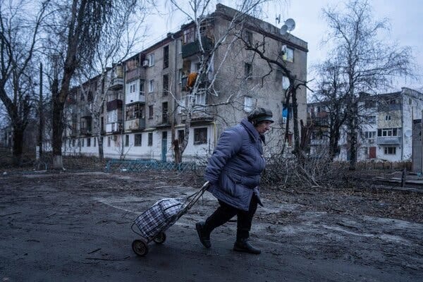 A woman walking past housing damaged by Russian shelling in Kupiansk, in northeastern Ukraine, on Wednesday.