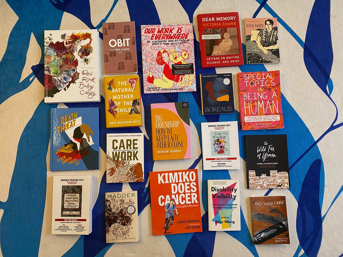 A selection of the books listed below laid out on a blue and white patterned rug.