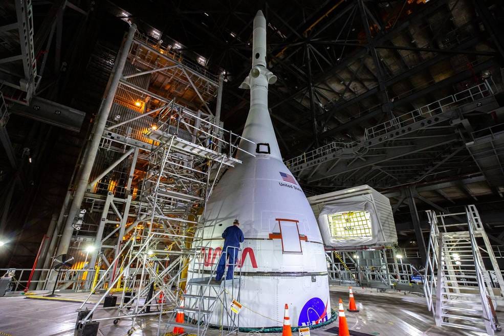 The Artemis I Orion spacecraft, secured on the Space Launch System and enclosed it is launch abort system, is in view high up in High Bay 3 of the Vehicle Assembly Building at NASA’s Kennedy Space Center in Florida on Jan. 10, 2022.