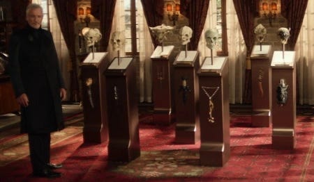 This image shows Q (played by John de Lancie) standing next to the skulls of seven extraterrestrial enemies defeated by the Confederation's General Jean-Luc Picard. All seven skulls are prominently displayed on plinths inside the general's Château Picard study. This image shows Q (played by John de Lancie) standing next to the skulls of seven extraterrestrial enemies defeated by the Confederation's General Jean-Luc Picard. All seven skulls are prominently displayed on plinths inside the general's Château Picard study.