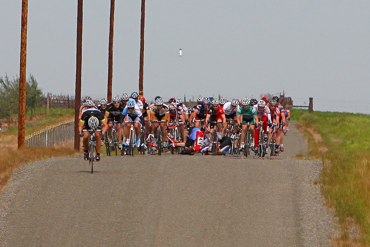Photo of a bike race crash. A water bottle floats in the air.