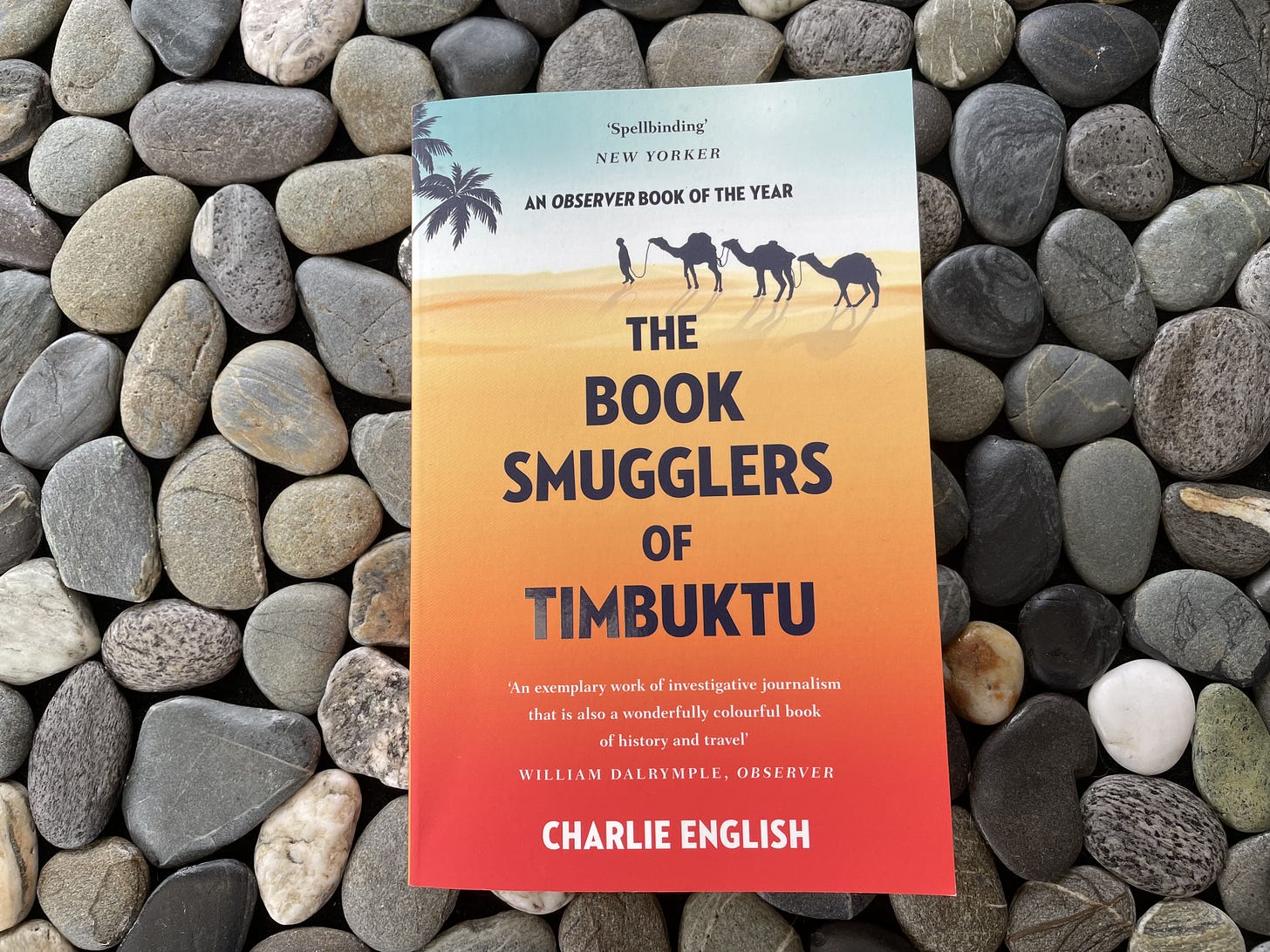 Cover of the book The Book Smugglers of Timbuktu set against a background of stones