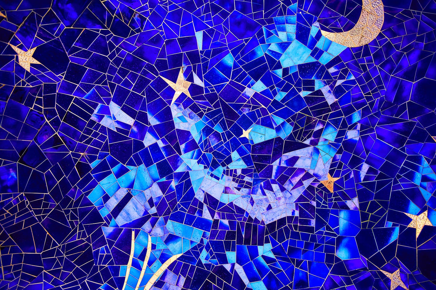 A mosaic made up of irregular pieces that look like colored glass, depicting a handful of golden stars against a dark blue sky.
