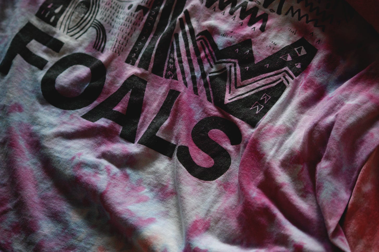 a purple shirt with a printed pattern and the logo of the band Foals