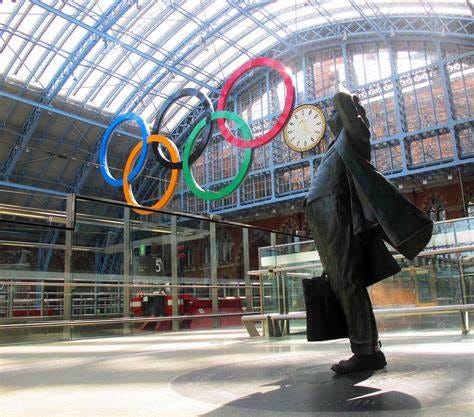 The statue of John Betjeman looks on at the Olympic logo at St Pancras International station in London in 2012