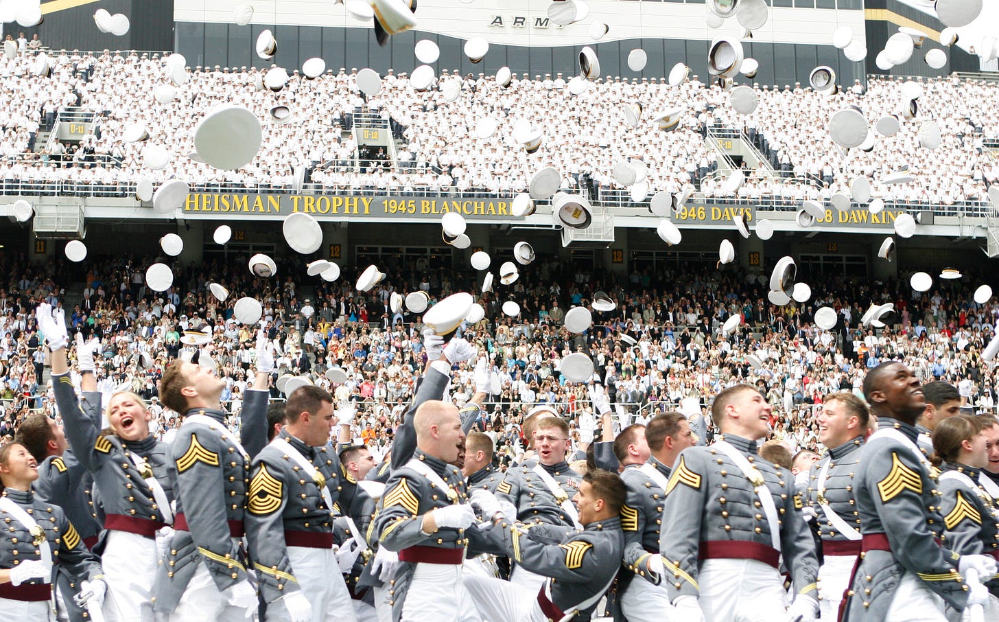 West Point graduation (2010) depicts a crowd of smiling Army graduates. They are celebrating their graduation by throwing their hats into the air. Photo is by Mike Strasser, West Point Public Affairs Office.