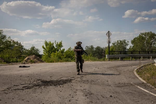 A member of the Ukrainian regional police force walked past a crater during a patrol near the Siversky Donets River, which divides the cities of Sievierodonetsk and Lysychansk, last week.