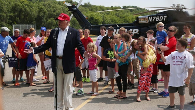 Presidential candidate Donald Trump talks to a group of kids waiting to get a ride in his helicopter in the parking lot of a baseball field last weekend in Des Moines.