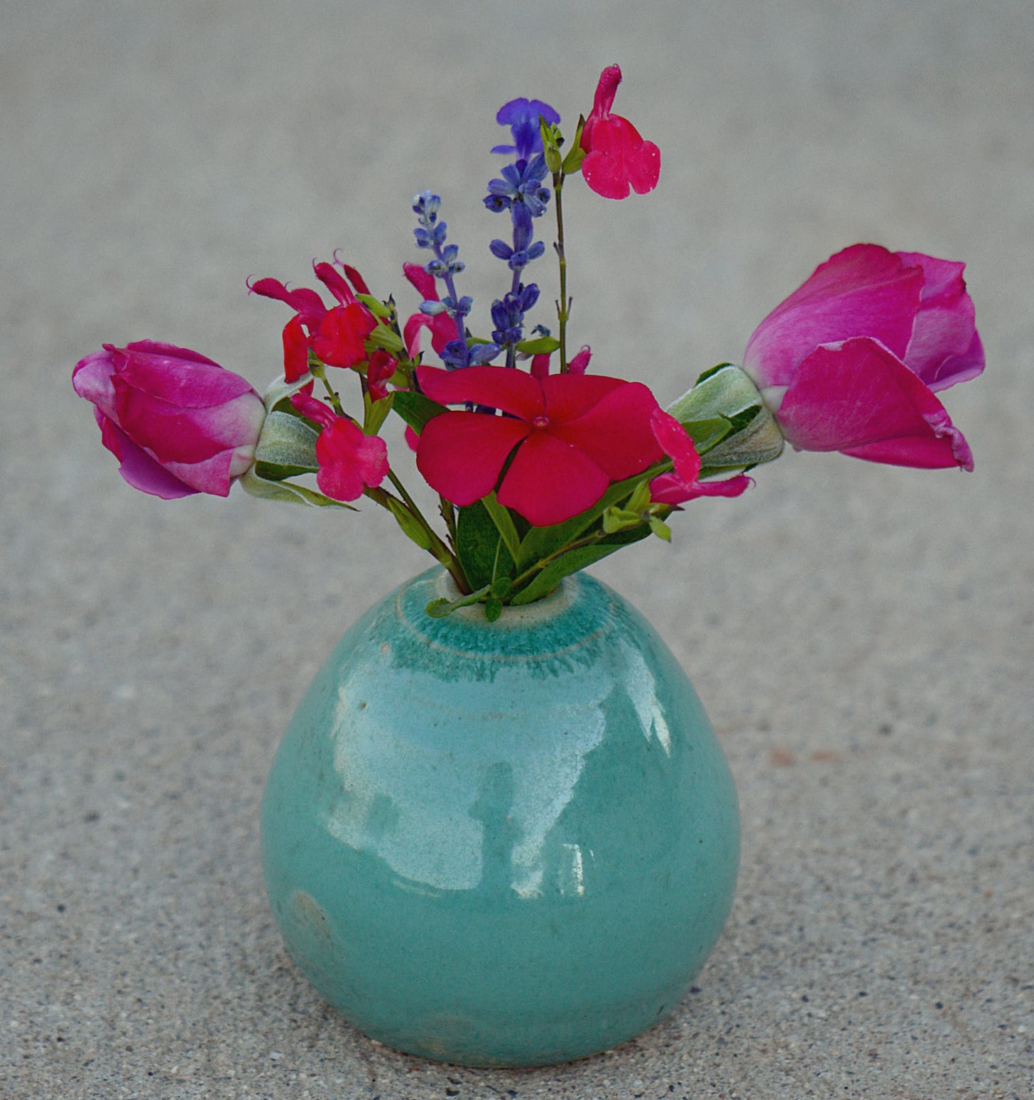 small stoneware vase with rosebuds, salvia and vinca