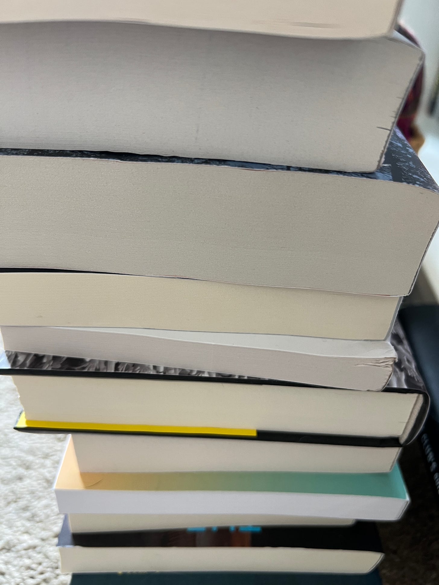 A stack of books where you cannot see the spines. 