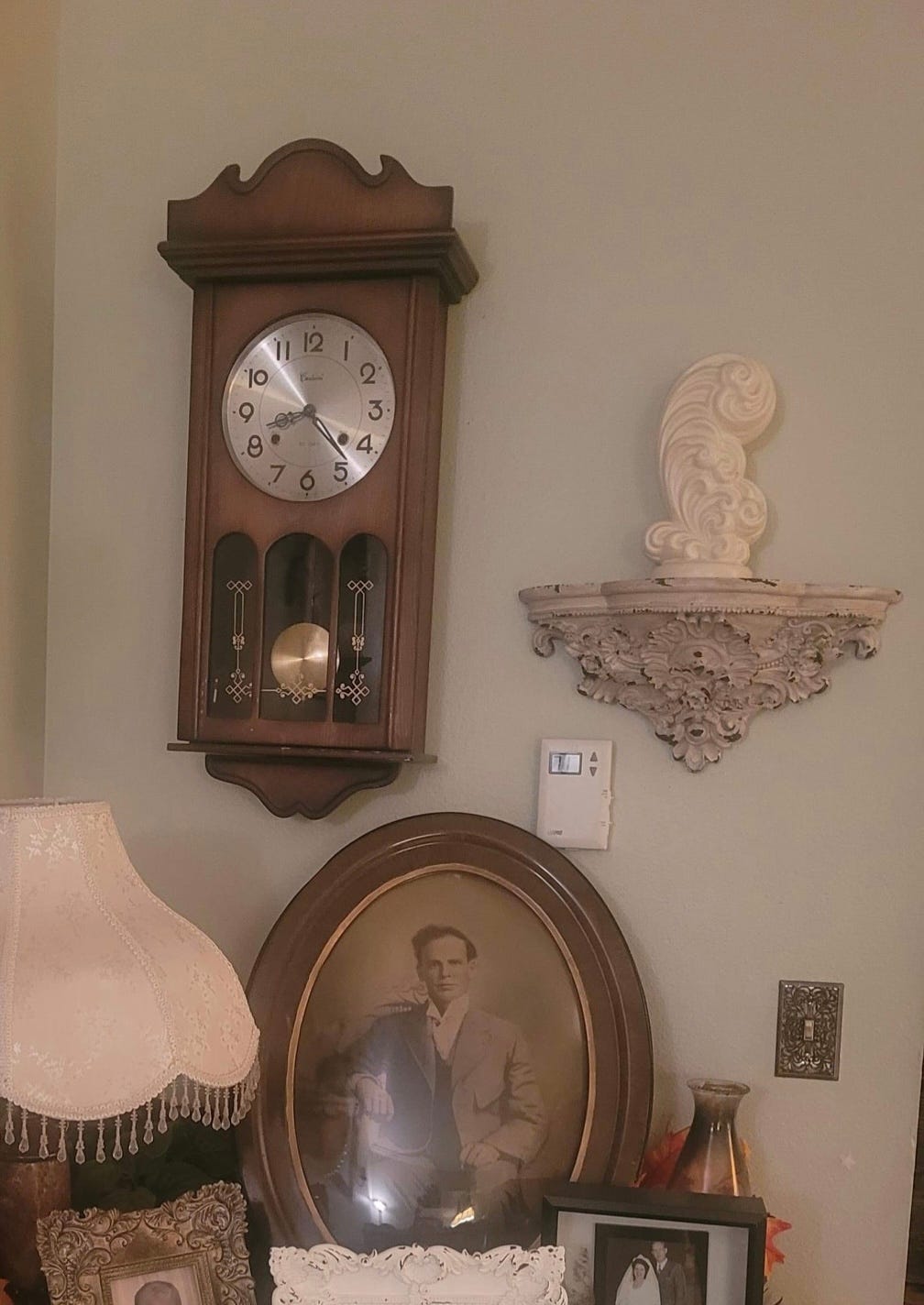 clock on wall, with old photographs below