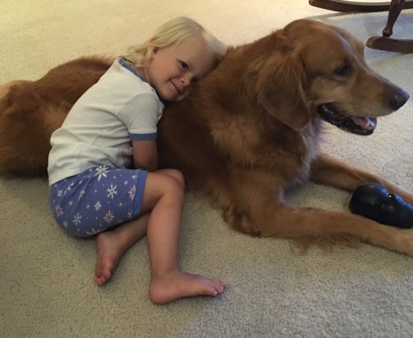 Hope, the daughter of loyal subscriber Anne, snuggles with her doggy companion, Tucker.