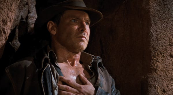 Indiana Jones placing his hand on his heart before taking the leap of faith
