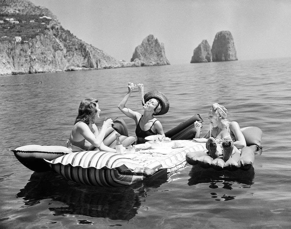 Three young women eat spaghetti on inflatable mattresses at Lake of Capri,  1939 (AP Photo / Hamilton Wright) : r/OldSchoolCool
