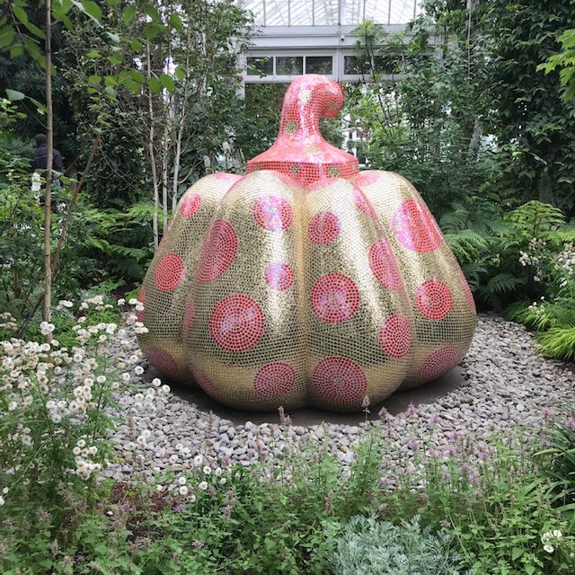 Sculpture of a large pumpkin covered in shimmery pink and gold tiles