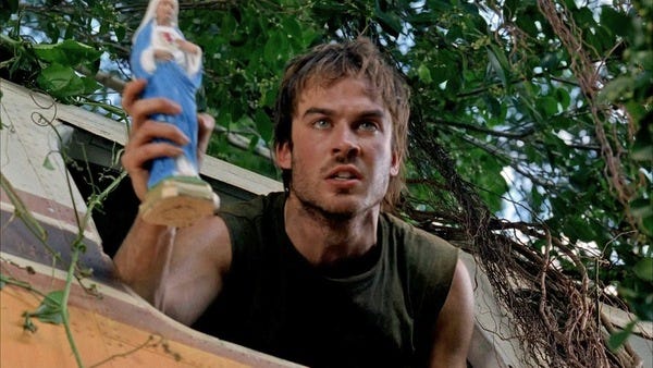 Boone Carlyle (Ian Somerhalder) pokes his head out of the window of a crashed Beechcraft. He is holding a statue of the Virgin Mary in his right hand.