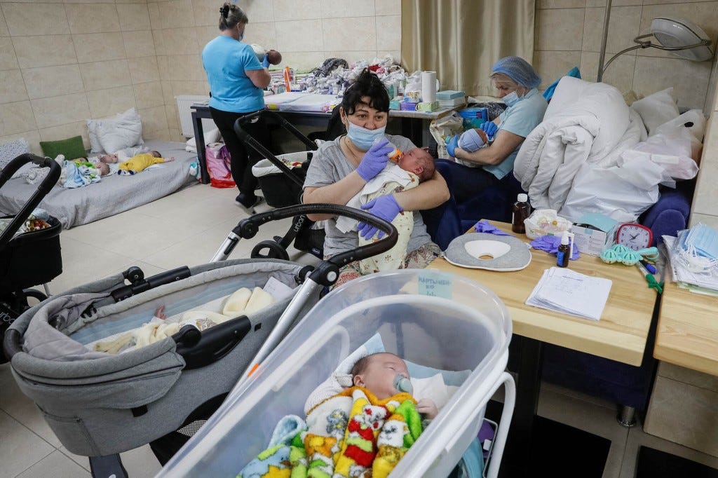 Nurse Oksana Martynenko feeds a surrogate-born baby.