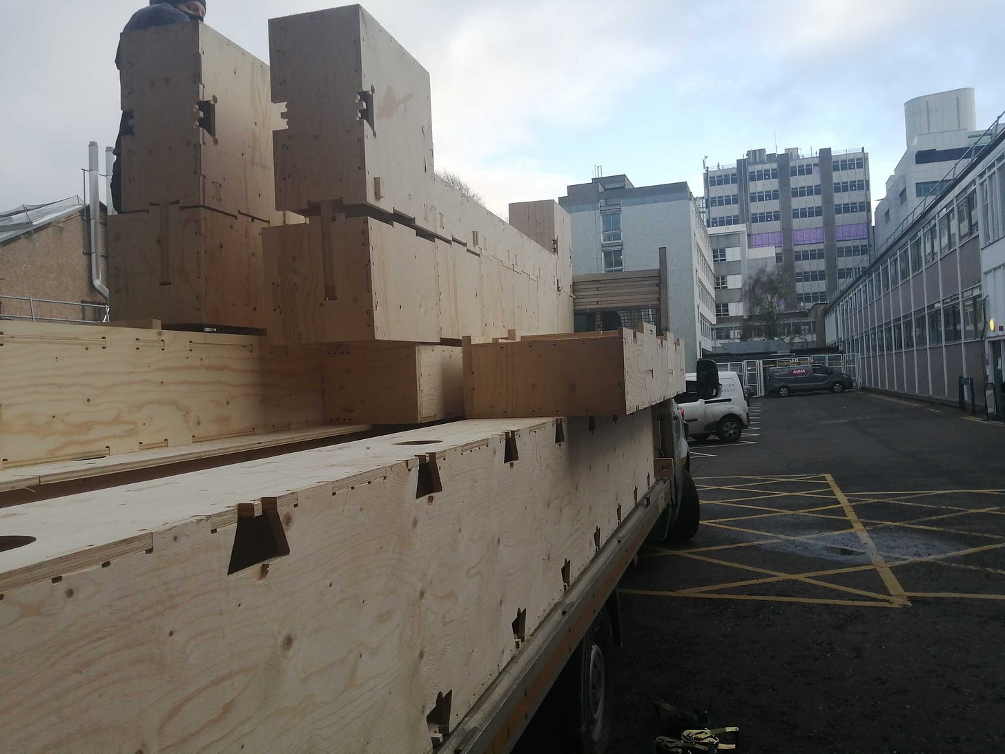 Picture of a lorry carrying a large number of Skylark timer blocks. The lorry is in a car park outside the University of Edinburgh.