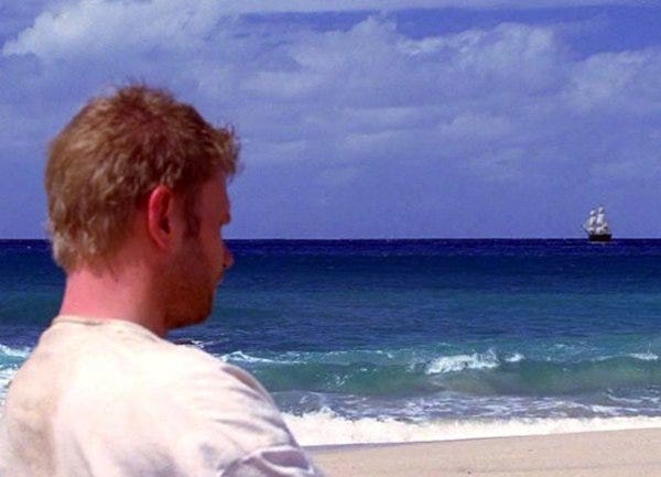 A shot over the shoulder of Jacob (Mark Pellegrino), who is looking out to sea at a galleon near the horizon.