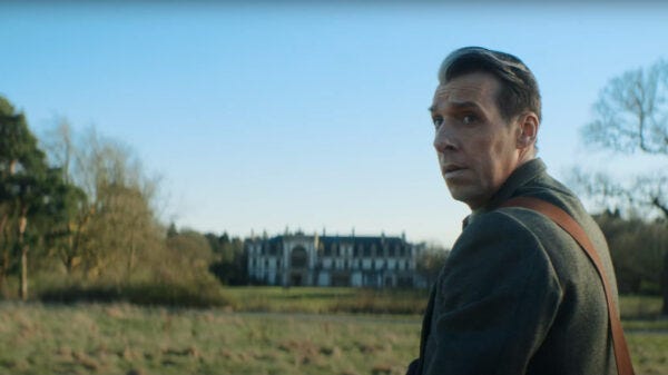 This image shows the Grand Serpent (played by Craig Parkinson), in the guise of a man named Prentis, hunting game in the field of an English country estate circa 1958. Prentis looks behind him, and over his left shoulder, at the camera. This image shows the Grand Serpent (played by Craig Parkinson), in the guise of a man named Prentis, hunting game in the field of an English country estate circa 1958. Prentis looks behind him, and over his left shoulder, at the camera.