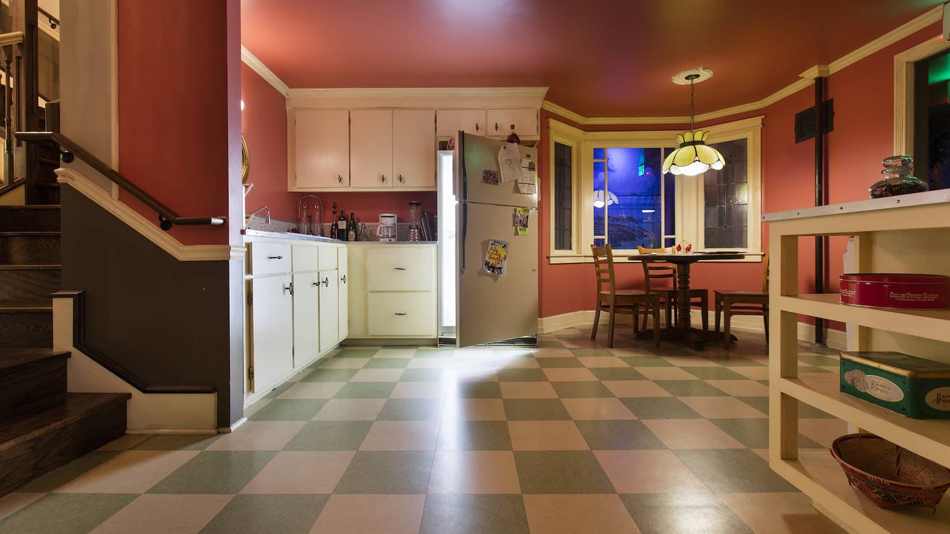 A kitchen with an open fridge from which a white light emanates