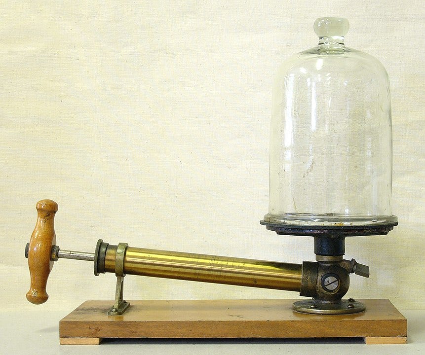 Vacuum pump and bell jar for vacuum experiments, used in science education during the early 20th century.