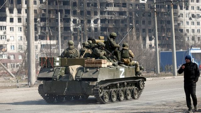 военные на бронемашине, отмеченной знаком Z, едут по улице Мариуполя, 24 марта