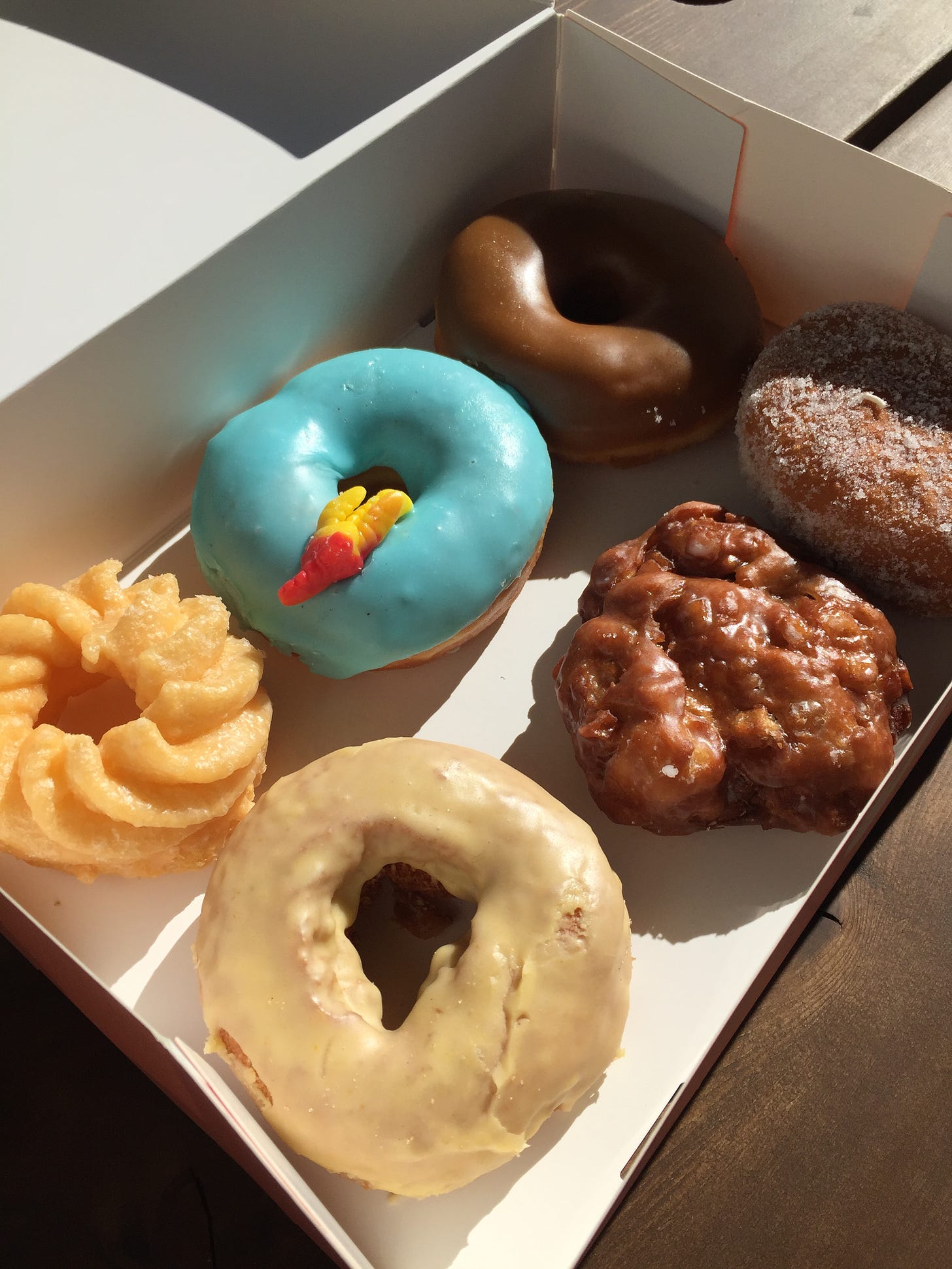 a variety of six donuts in a white box