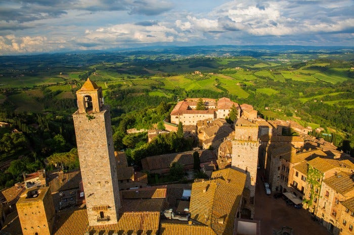 A medieval hill town in the Tuscany region of Italy, tall buildings and countryside stretching out into the horizon