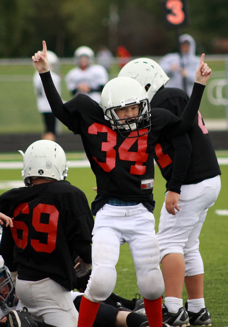 Triumph and heartbreak are consistent themes in any sport. But, the feelings concentrated when kids are playing. In this photo, a young football player reacts to his own good effort, and he looks to his parents in the stands for validation. 