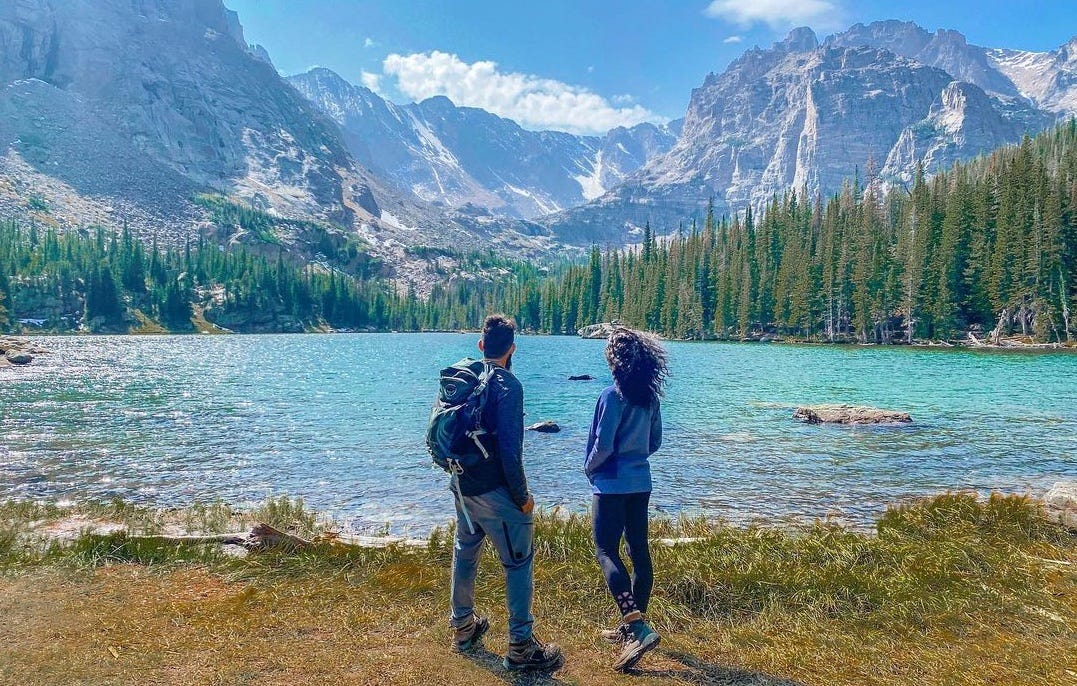 Ali and Ravine hiking in mountains with lake